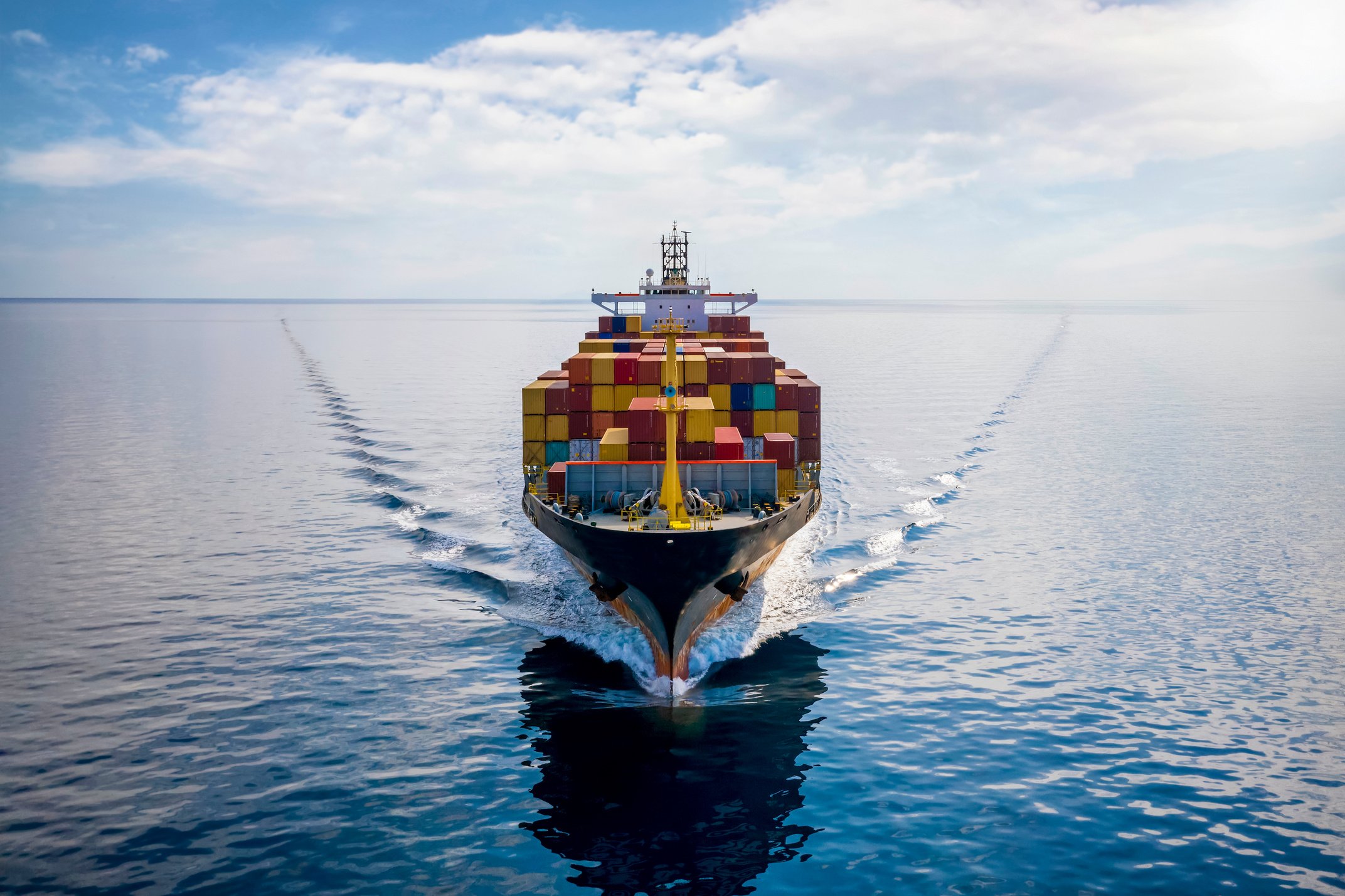 Aerial front view of a loaded container cargo vessel